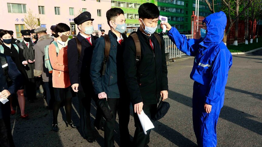 Students in Pyongyang wearing face masks have their temperature checked as a precaution against the new coronavirus.