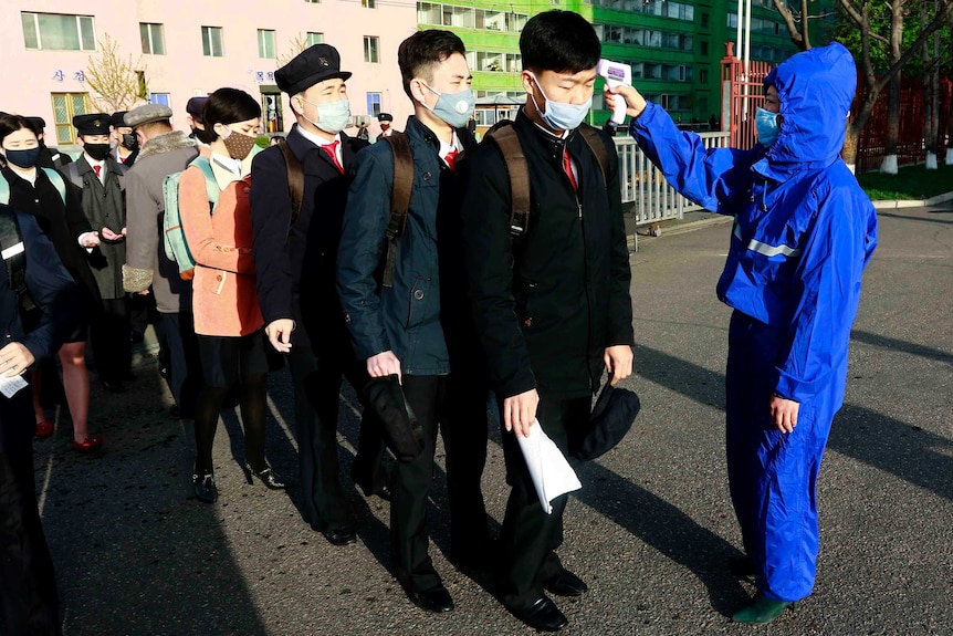 Students in Pyongyang wearing face masks have their temperature checked as a precaution against the new coronavirus.