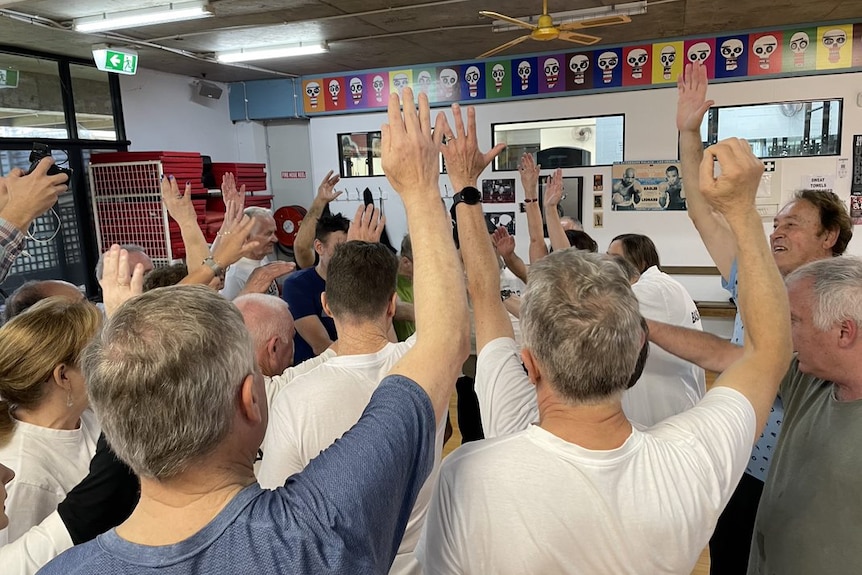 A group have their hands up at the St Kilda PCYC gym