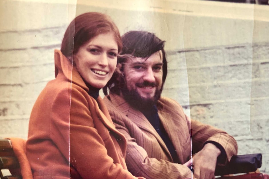 A picture of an old photograph of a young couple in the 70s. The man is in a wheelchair.