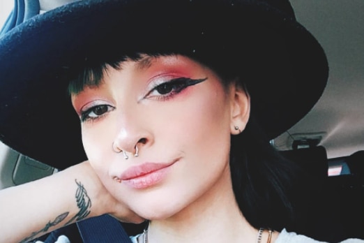 Girl in a black hat posing for a selfie in her car