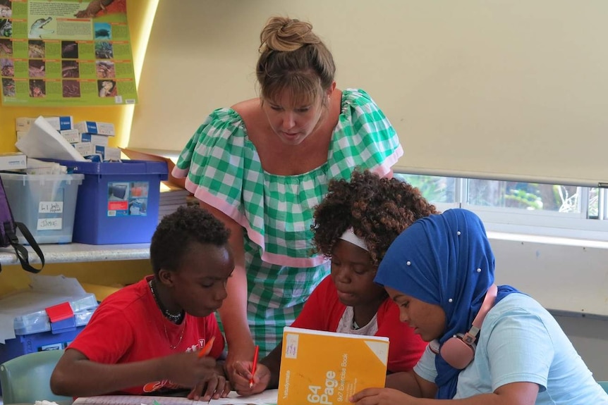 Three students in a classroom with teacher Lani Jackson at Milpera State High School at Chelmer in Brisbane.