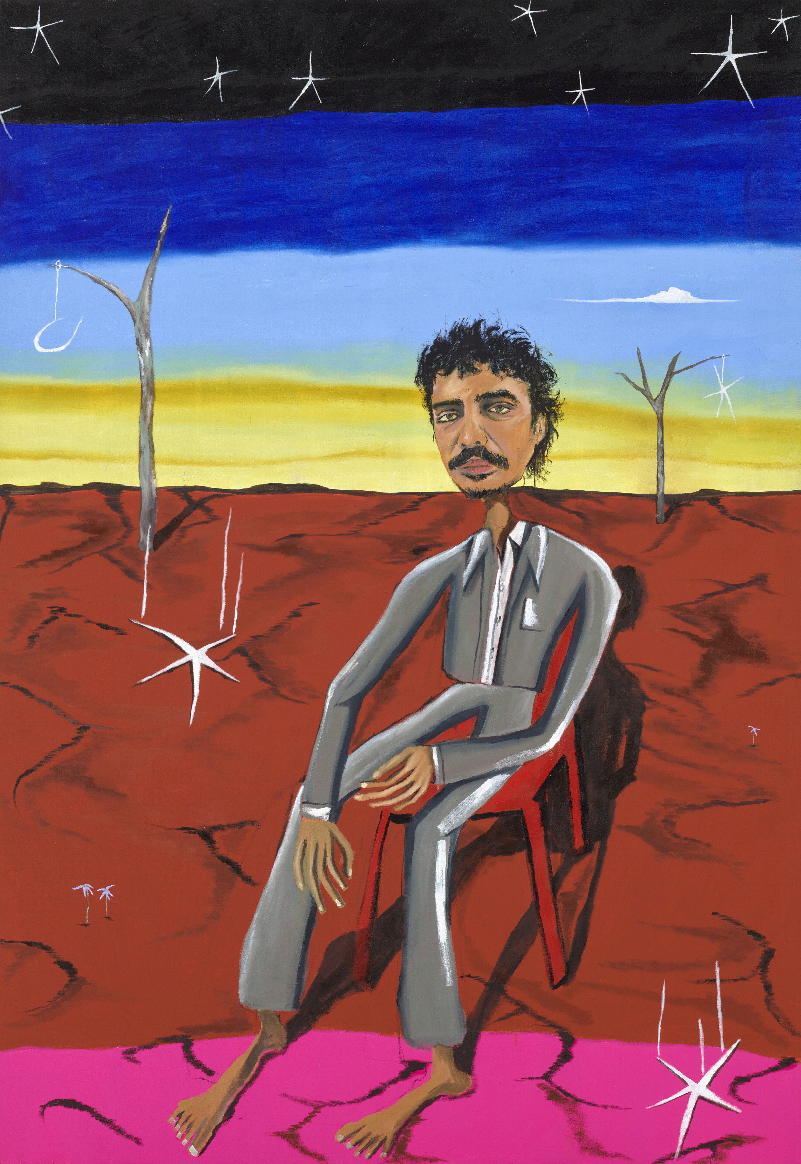 A portrait of Tony Armstrong, an Indigenous man with dark curly hair and a moustache sitting in outback Australia.
