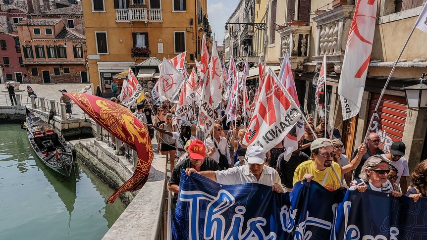 Protesters in Venice march alongside a canal in the city centre.