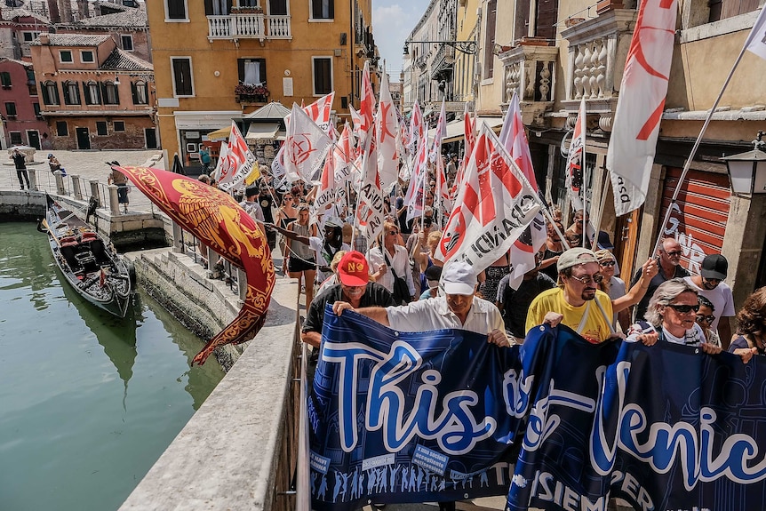 Protesters in Venice march alongside a canal in the city centre.
