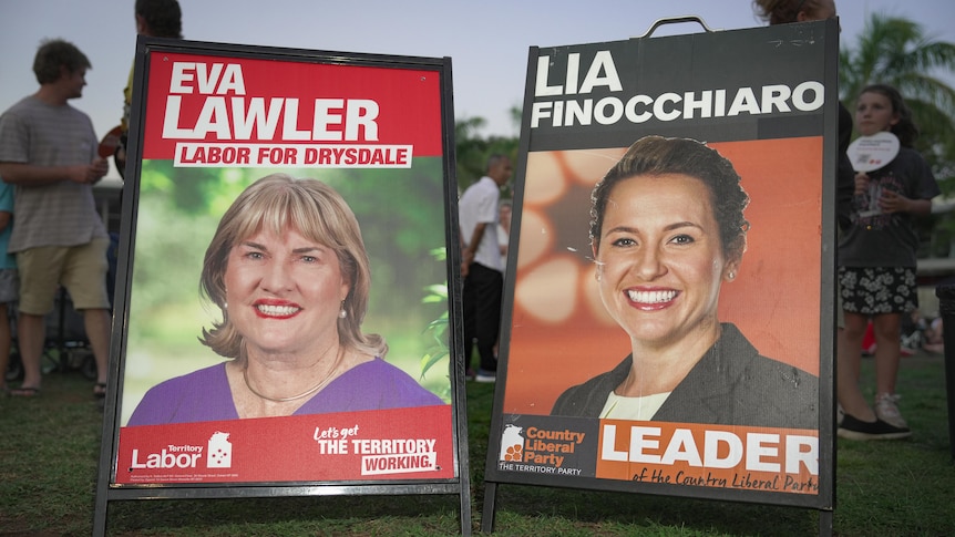 Two corflute signs side-by-side on the ground, showing the faces of NT politicians Eva Lawler and Lia Finocchiaro.
