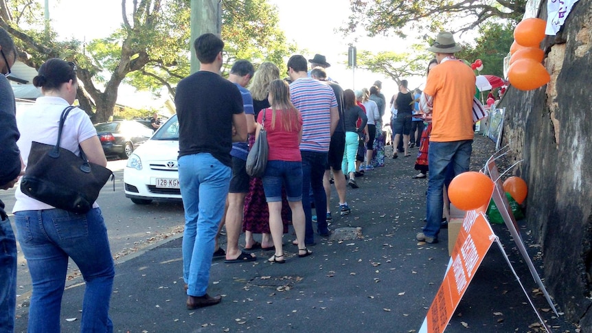 Voters queue around the block outside a polling station in Brisbane during the federal election