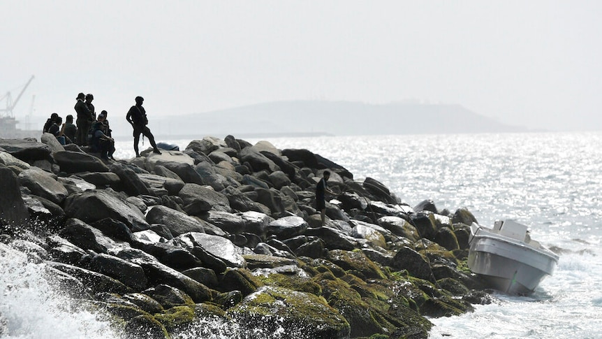 Security forces shown guarding the shore area and a boat in the port city of La Guaira, Venezuela.