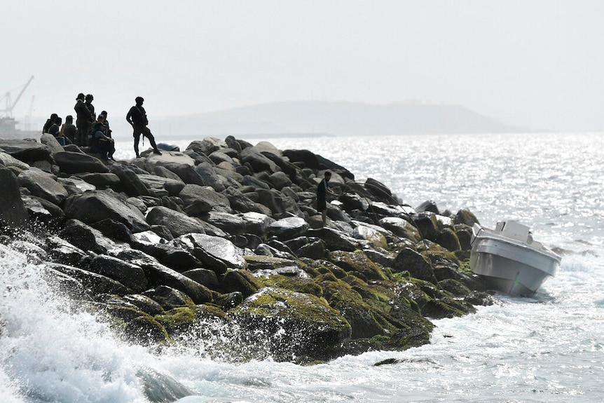 Security forces shown guarding the shore area and a boat in the port city of La Guaira, Venezuela.