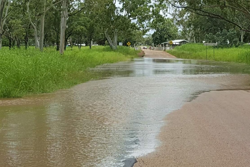 Water spills over from the Waterhouse River onto the road near Beswick community