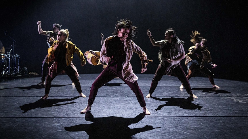 6 dancers thrashing to white noise with a drum kit in the corner