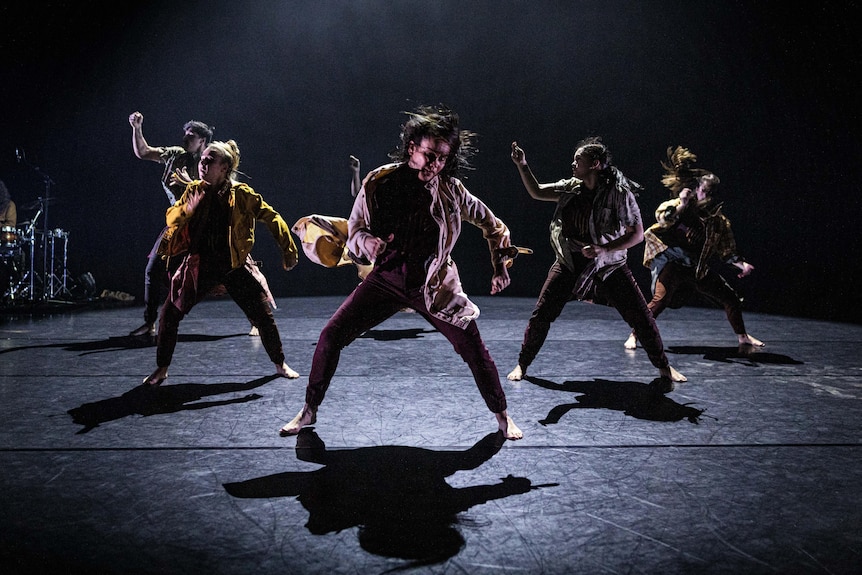 6 dancers thrashing to white noise with a drum kit in the corner