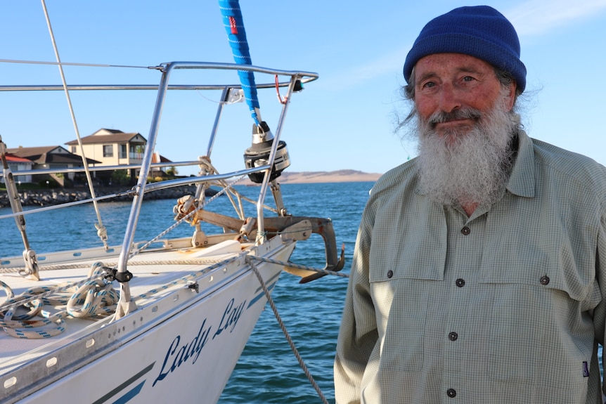 Man standing on right by bow of yacht with name lady lay