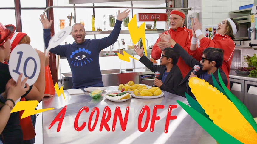 Chef George Colombaris with his hands in the air in a kitchen, group of kids cheer, text overlay reds "A corn off"