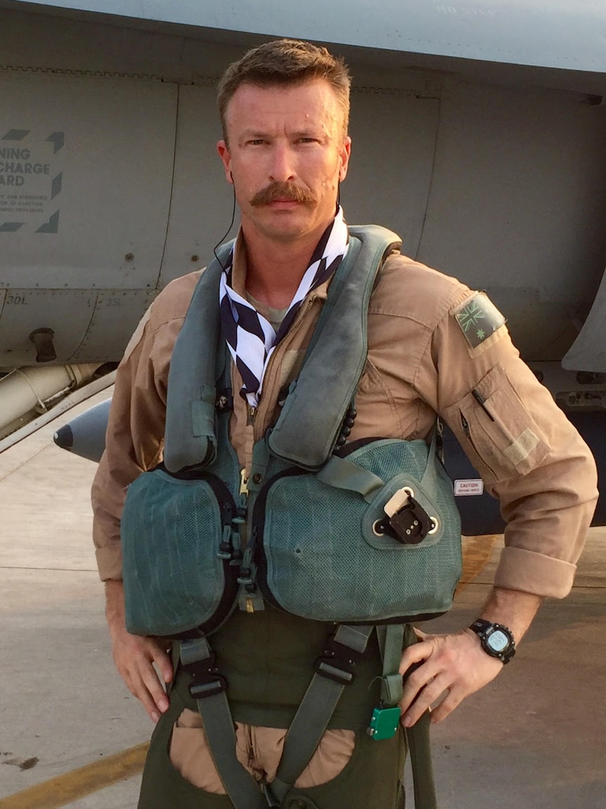 A RAAF airman stands in front of a military aircraft.