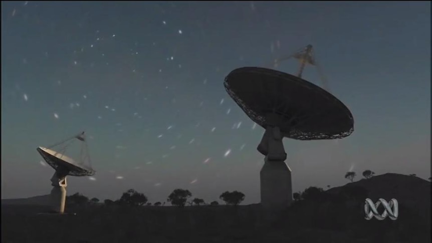 A large radio telescope against a night sky full of stars
