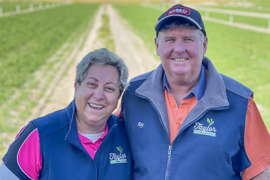 A man and a woman standing in a green paddock.