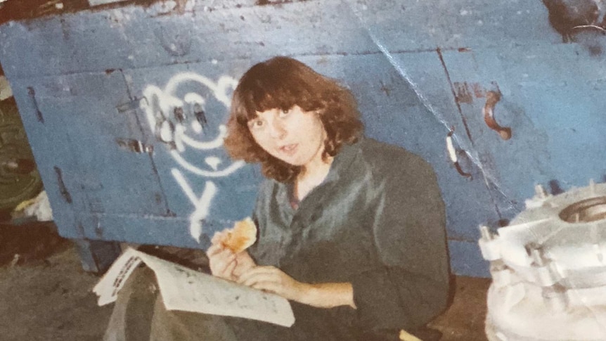 Yvonne Ward sitting eating a sandwich while sitting in a workshop