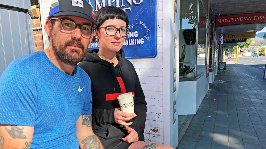 Niall Harden and Sarah Wyllie sit outside with takeaway coffees.