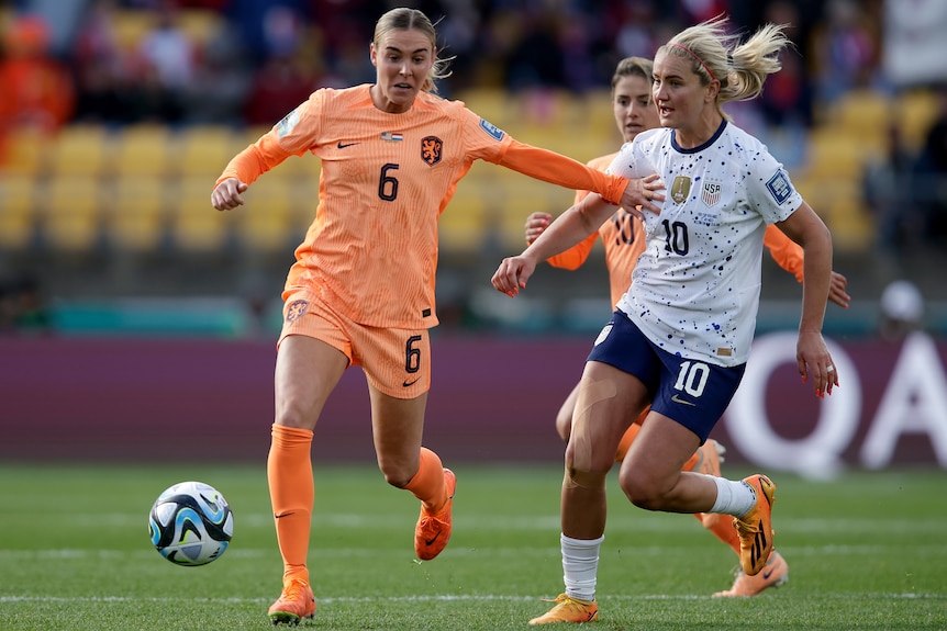 A Dutch player dribbles the ball as she is challenged by a USA opponent at the Women's World Cup.