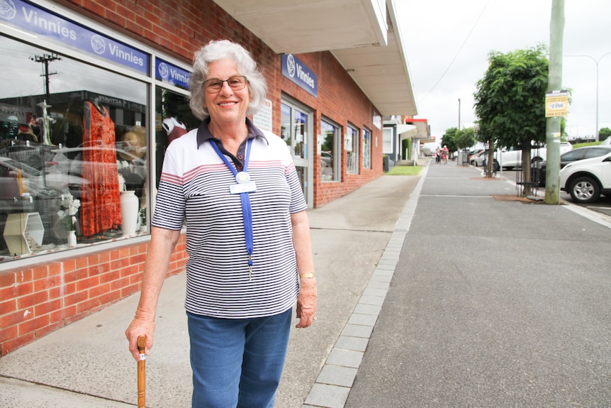Fay Crozier stands on the sidewalk with a walking stick