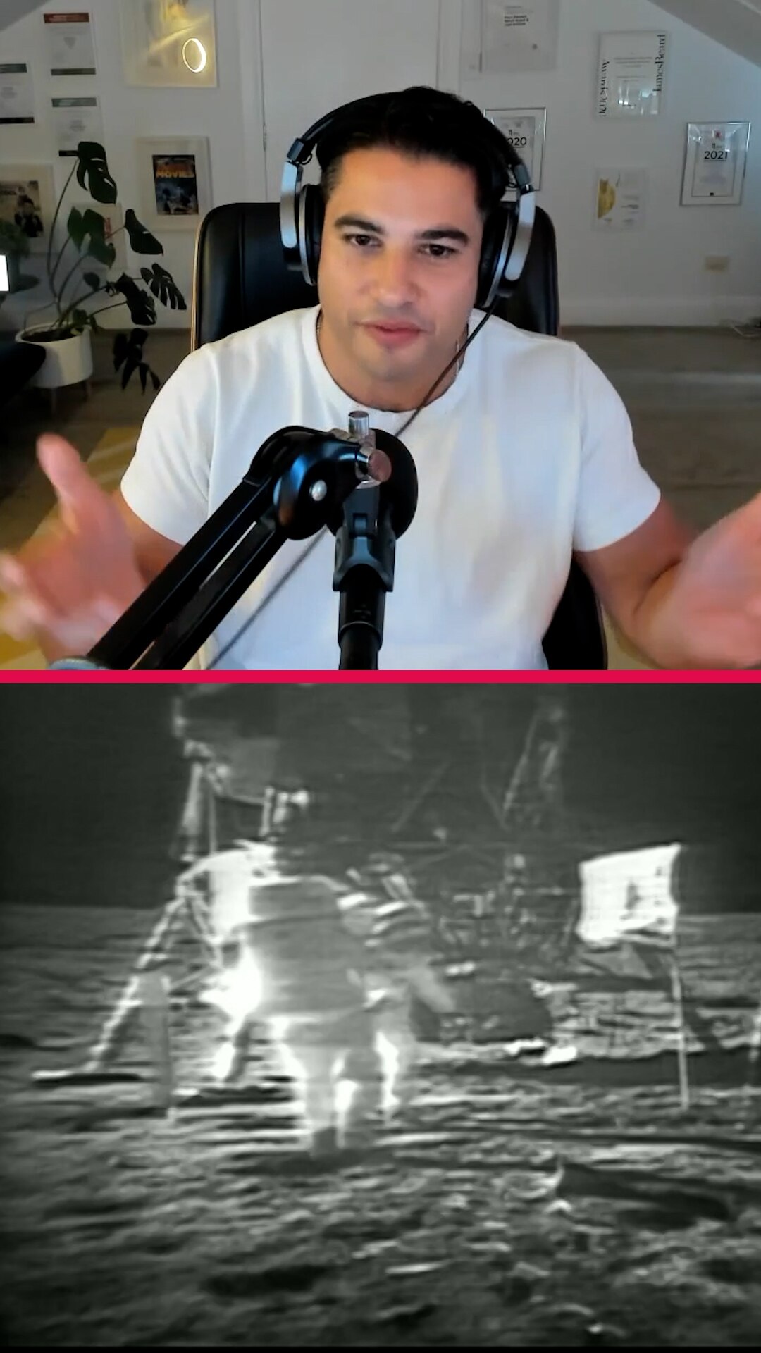 Marc Fennell wears over-ear headphones and is front of a microphone hands outstretched, below black and white man on moon