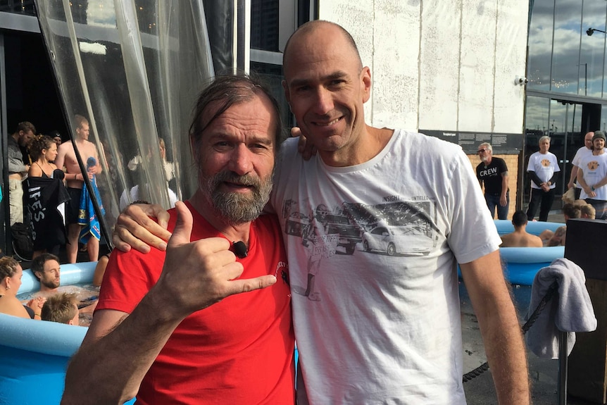 Two men embrace in front of a conference centre