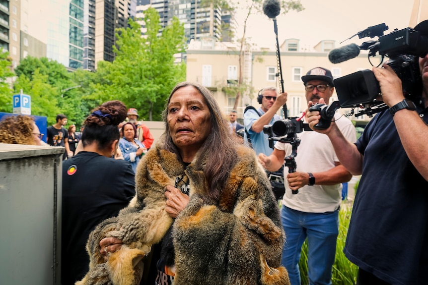 A woman wearing a possum-skin cloak.