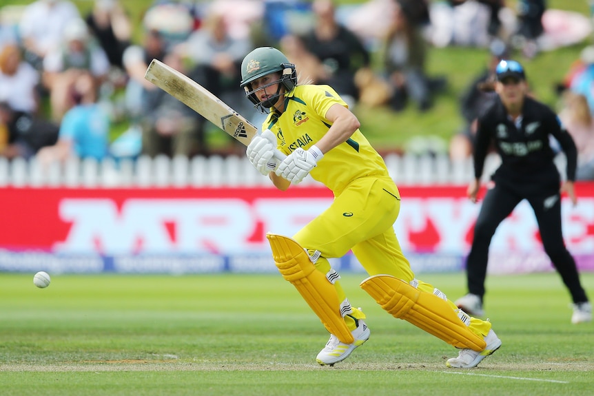 Ellyse Perry bats wearing yellow cricket kit