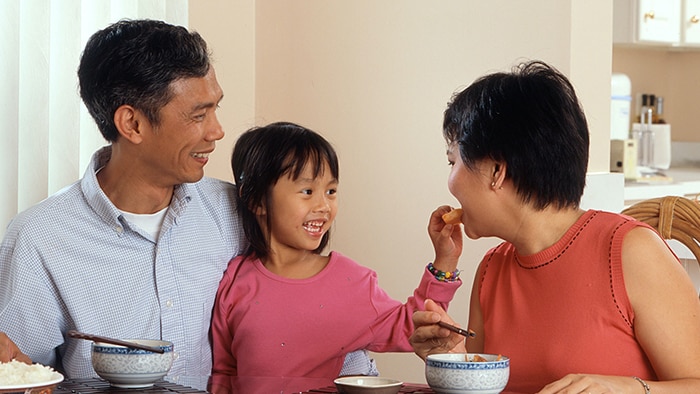 Child sitting at a table with adults