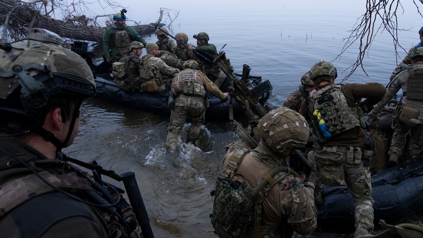 Soldiers are pictured getting on boats.