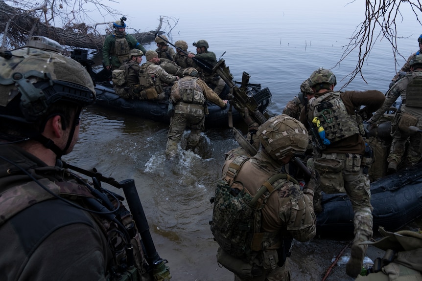 Soldiers are pictured getting on boats.
