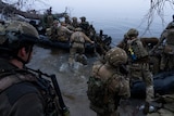 Soldiers are pictured getting on boats.