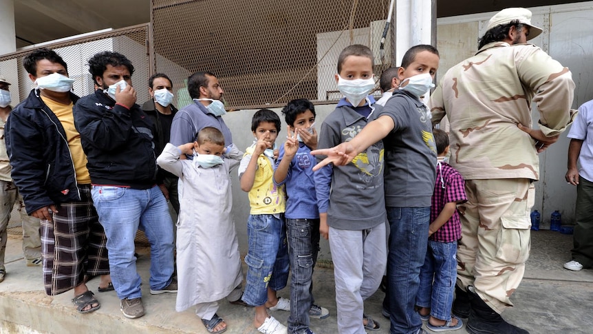 Men and children queue to look at the corpses of Moamar Gaddafi and his son Mutassem in Misrata