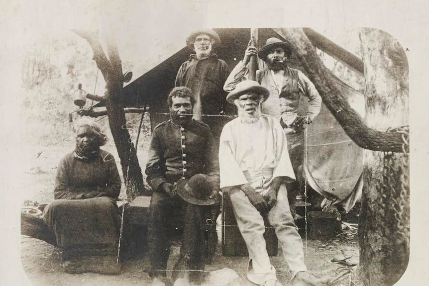 a black and white photo of a group of Indigenous people in colonial dress