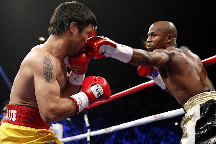 Floyd Mayweather Jr (R) connects with Manny Pacquiao during welterweight title bout in Las Vegas.