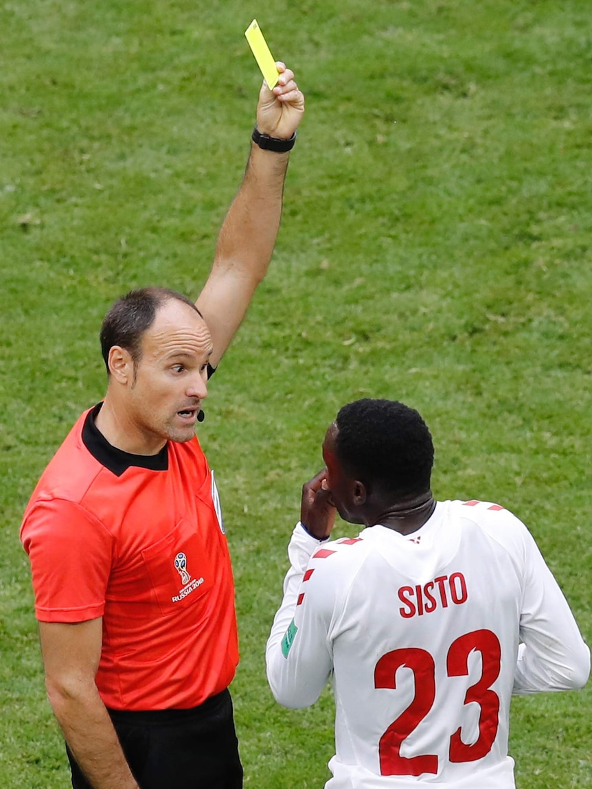 Referee gives Denmark's Pione Sisto a yellow card