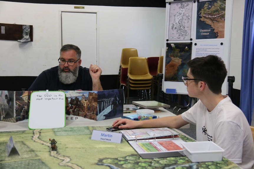 A man and children play Dungeons and Dragons around a table.