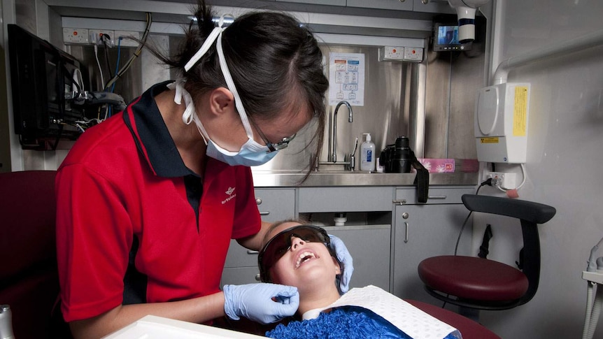 Dentist and child patient from Royal Flying Doctor Service mobile dental service