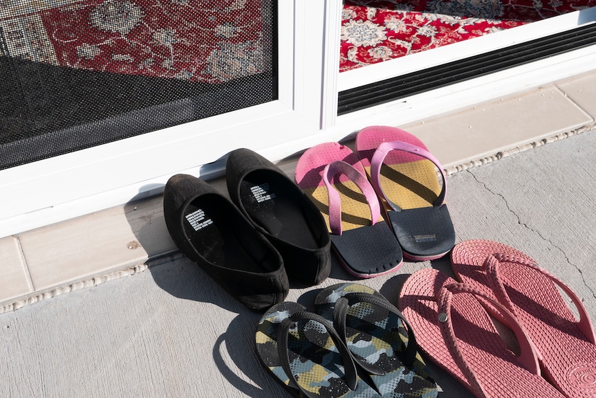 Exterior scene of a shoes lined up outside the home of Afghan Australians