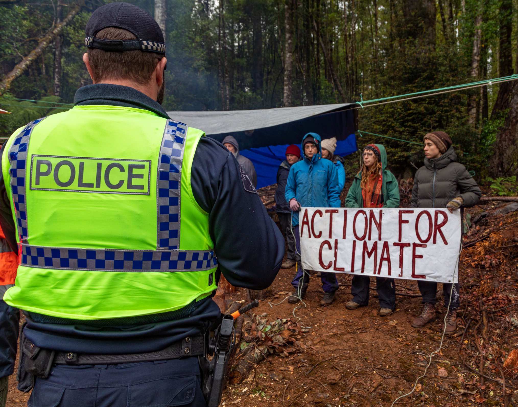 Tasmania Police officer looks at protesters at a site in the Tarkine forest, Tasmania, February 2020.