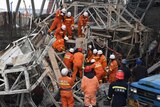 Rescue workers look for survivors among the wreckage of a collapses platform.