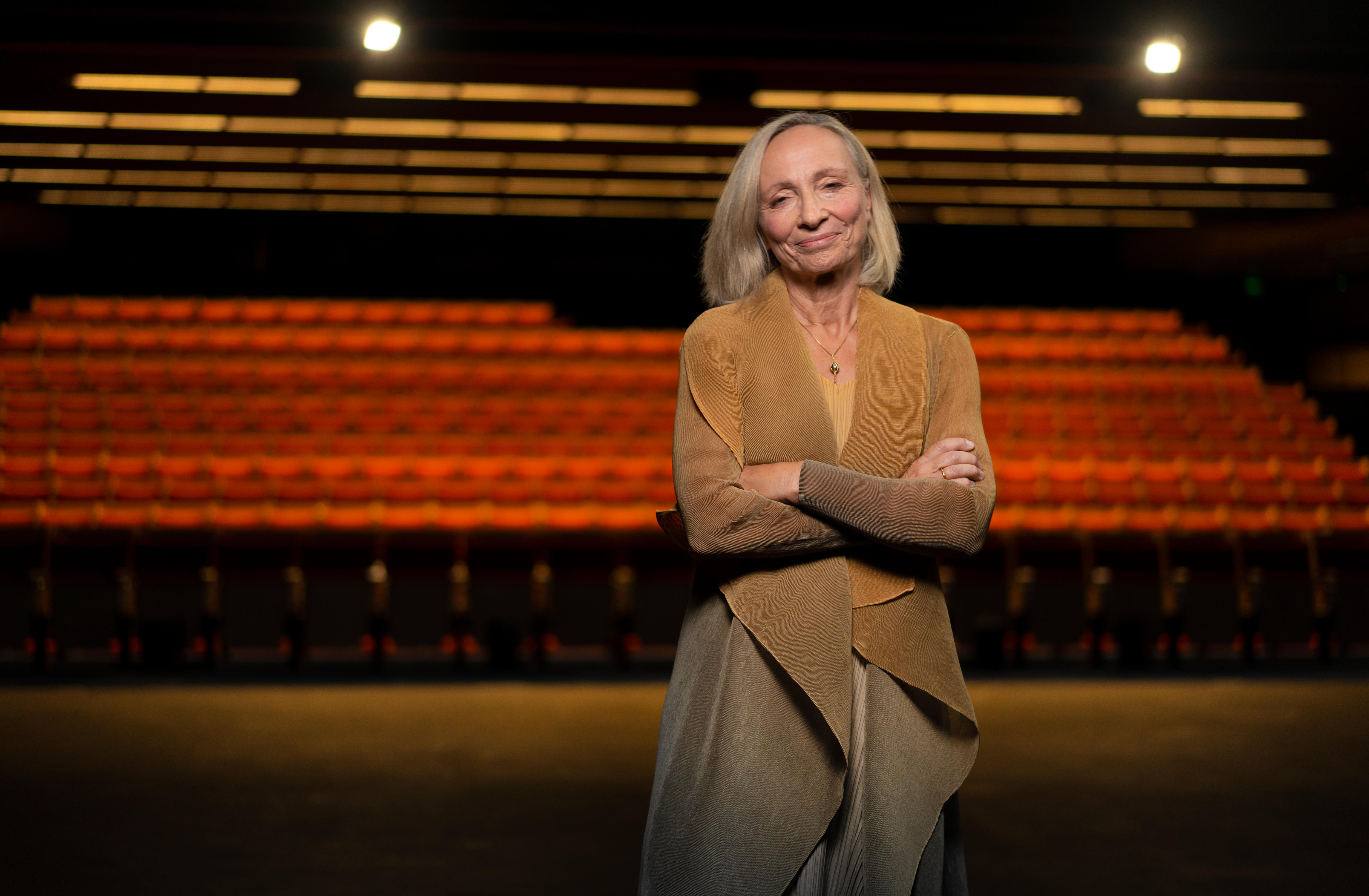 A woman in a brown coat stands on a 