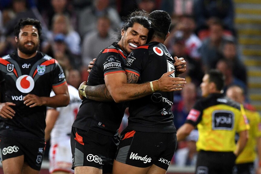 Tohu Harris smiles rests his head on Ken Maumolo's shoulder as the pair hug after scoring a try.
