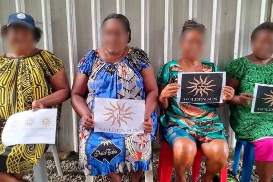 PNG women sitting down holding a piece of paper that says golden sun