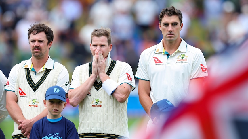 Australian cricketers Travis Head, Steve Smith and Pat Cummins stand for the national anthem before a Test against New Zealand.