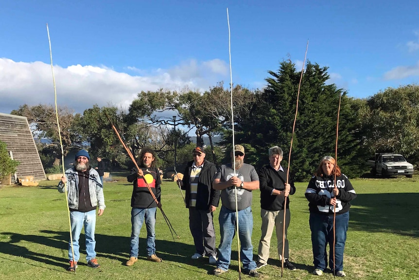 People hold spears at a workshop