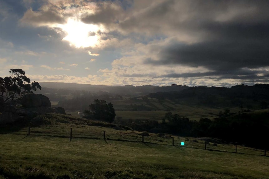 A photo shows the undulating hills over a landscape