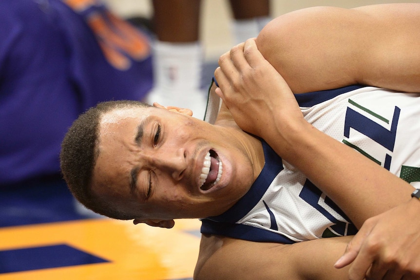 Utah Jazz guard Dante Exum grabs his left shoulder in pain against the Phoenix Suns.