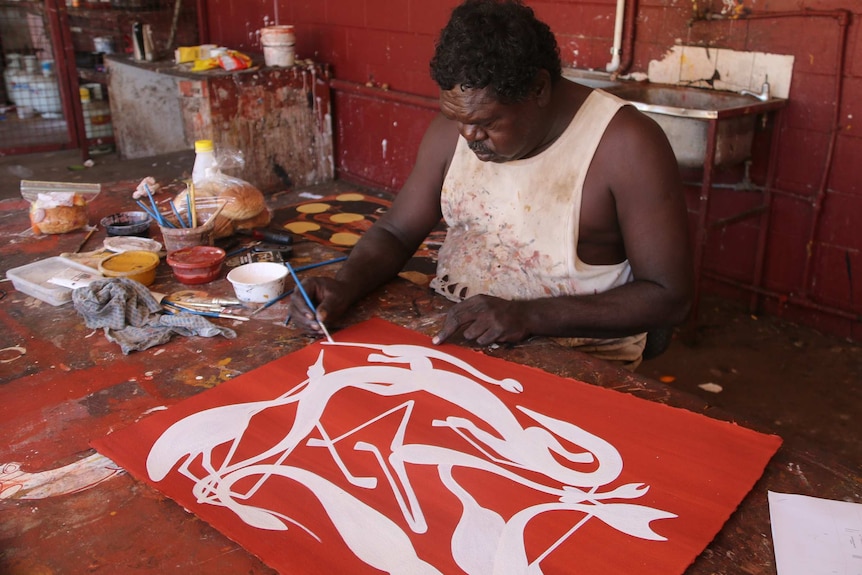 Artist and co-manager Gabriel Maralngurra paints in traditional ochre paints.